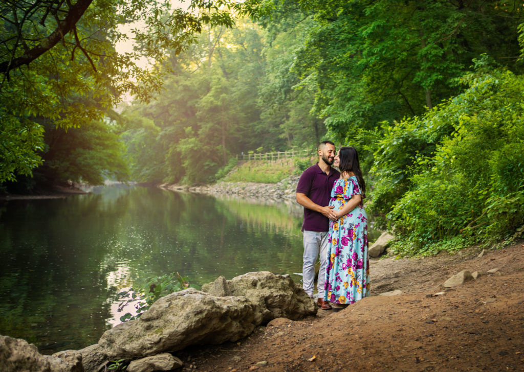 Maternity session with couple standing near the Wissahickon creek