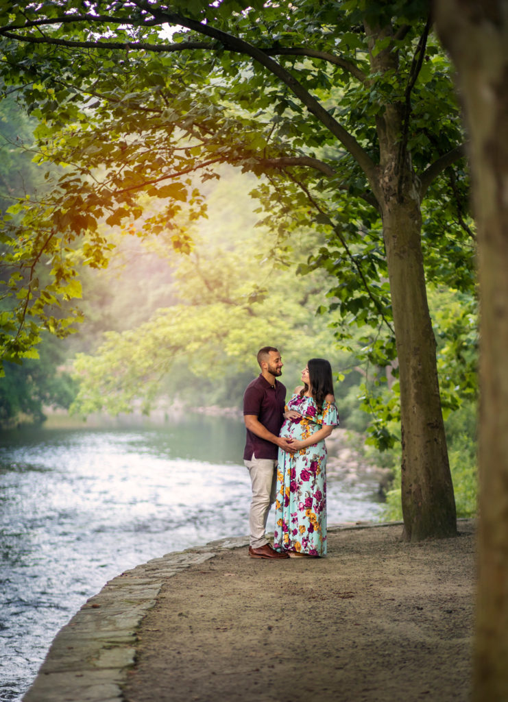 Maternity session with couple holding hands near the Wissahickon creek
