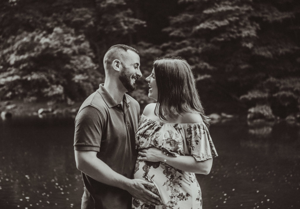 Maternity photo session with couple laughing near the Wissahickon creek in Philadelphia