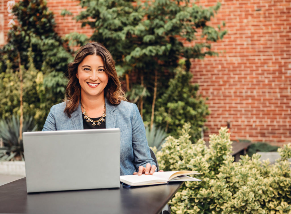 Professional branding photos with a woman sitting at a table with a laptop