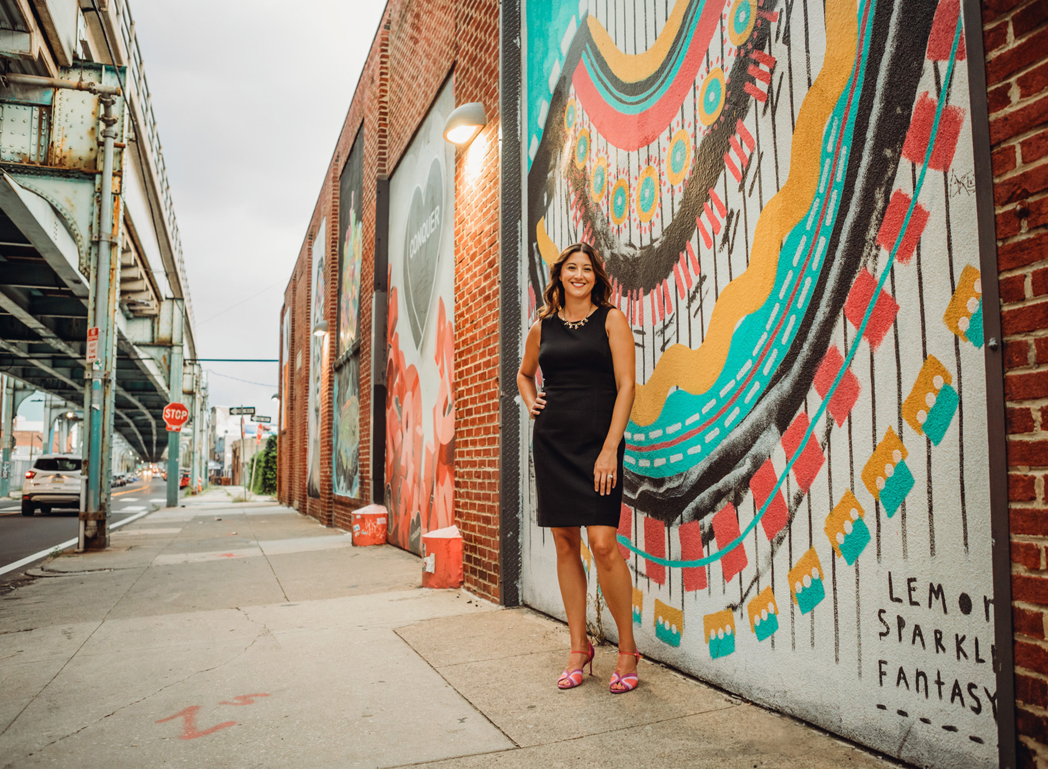 Personal branding photo of woman standing in front of Philadelphia mural