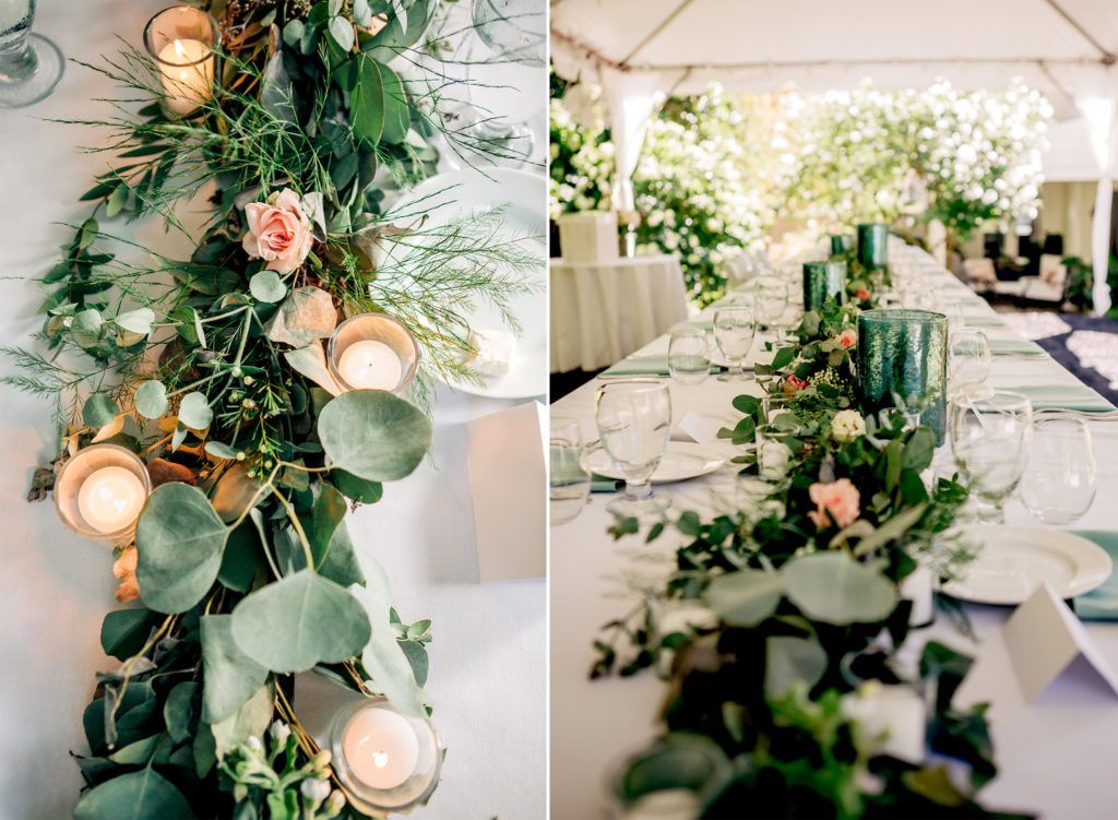 Flowers and candles on a long white table at a backyard wedding
