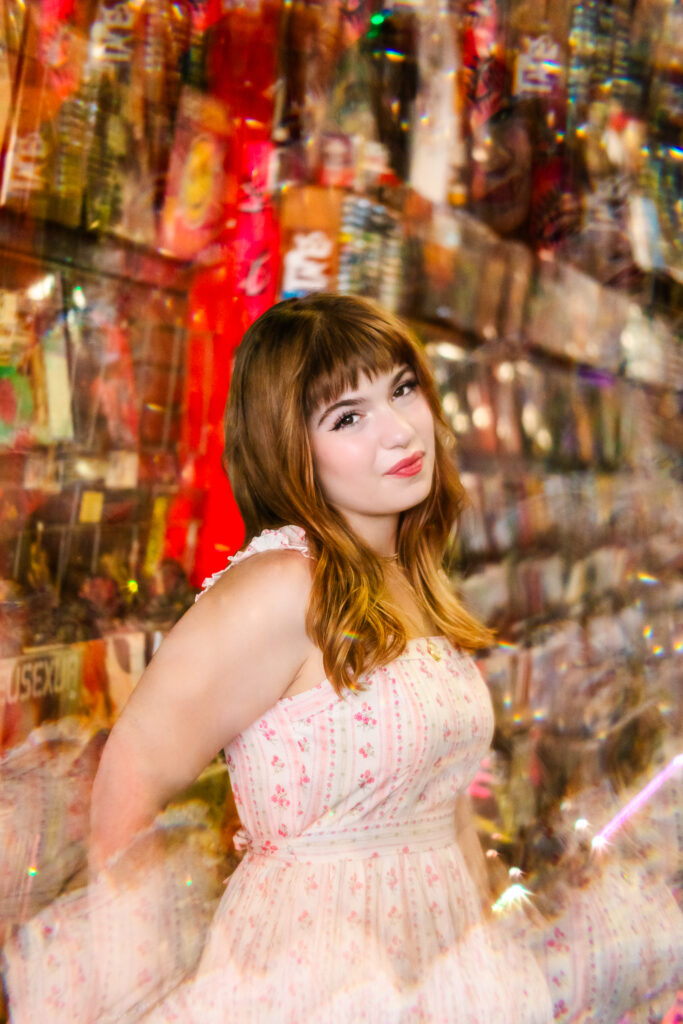 Artistic senior portrait of Lyla inside a record store with colorful reflections and layered light shot through a prism.
