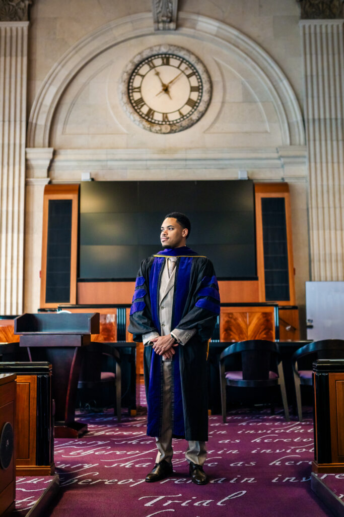 Law school graduate wearing academic regalia during a graduation photoshoot at Drexel University in Philadelphia
